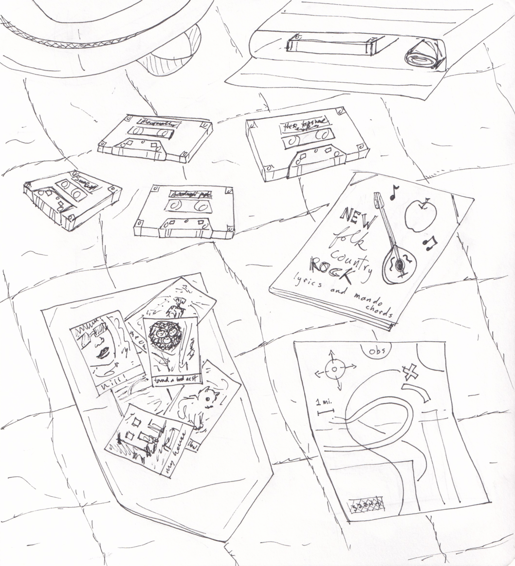 Items spread out on a bedspread: the corner of Greg's backpack; an open package with a cassette case; four cassette tapes, one of which is labeled THESE TAPES HAVE EYES and another of which says GOODNIGHT PEOPLE; a zine with an apple, mandolin and music notes on the cover that says New Folk Country Rock lyrics and mando chords; a flattened envelope with several instant photos -- a woman's selfie with the caption HIIII, a bird's nest with the caption FOUND A BIRD'S NEXT, a house with the caption MY HOUSE, a kitten; and finally a treasure map.